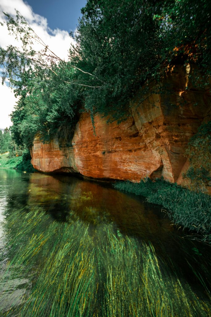 Stunning view of sandstone cliffs by a calm river in Gauja National Park, Latvia.