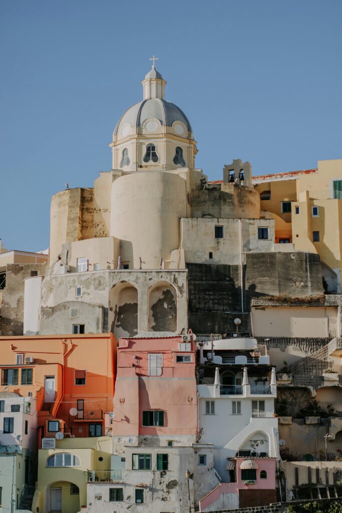 Vibrant multicolored buildings with a prominent church dome in a quaint Italian town.